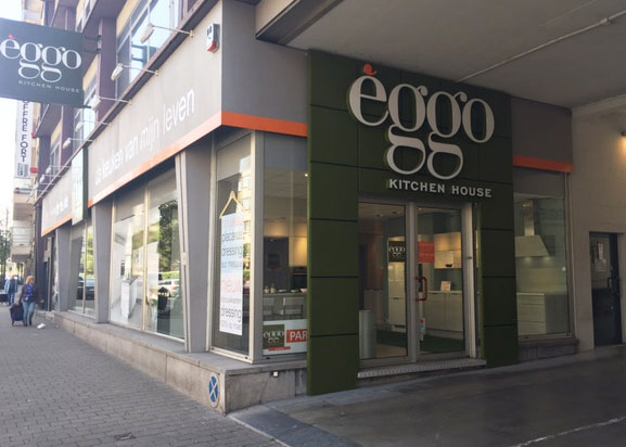 Façade de l'enseigne èggo Kitchen House avec vitrines, située sur un trottoir bordé de bâtiments urbains.