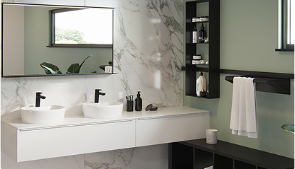 Deux lavabos blancs avec robinets noirs sur un plan de travail en marbre, miroir mural, étagère noire avec produits et serviette blanche.